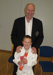 The feeling of passing your first grading! Sensei Poynton congratulates a happy club member.